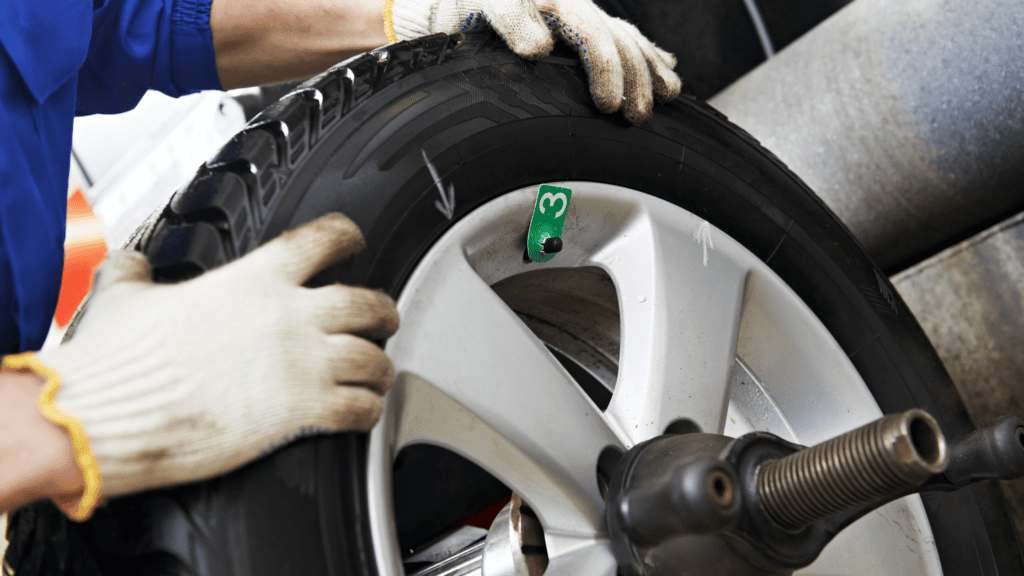 Technician adjusting wheel placement on wheel balancer