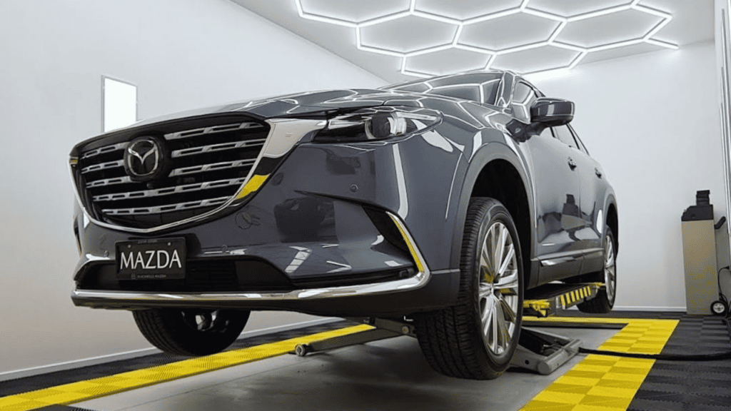 Grey sedan undergoing servicing